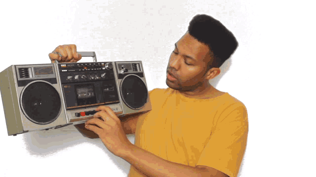 a man in a yellow shirt is holding a boombox that says sanyo