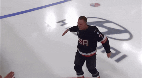 a man wearing a sa jersey stands on a ice rink