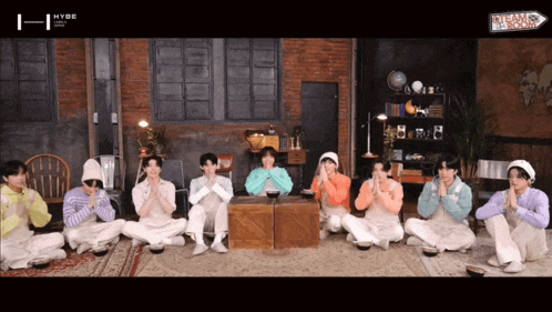 a group of young men are sitting in a room with a sign that says dreams come true