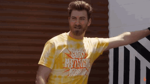 a man wearing a yellow shirt that says good morning morning