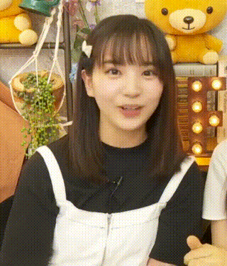 a close up of a girl 's face with a teddy bear behind her .