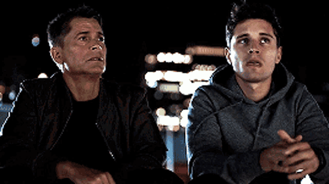 a man and a boy are sitting next to each other and talking