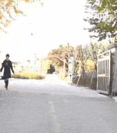 a woman is walking down a street with a bag in her hand .