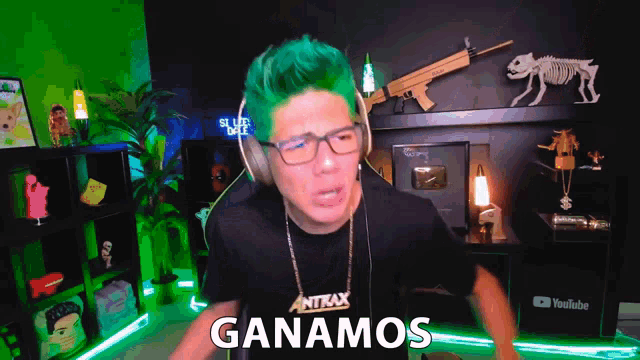 a man with green hair is wearing headphones and a shirt that says antax on it