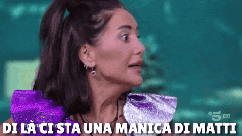 a woman is wearing a purple top and earrings and has the words di la cista una manica di matti above her