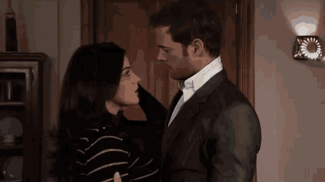 a man in a suit and tie is kissing a woman