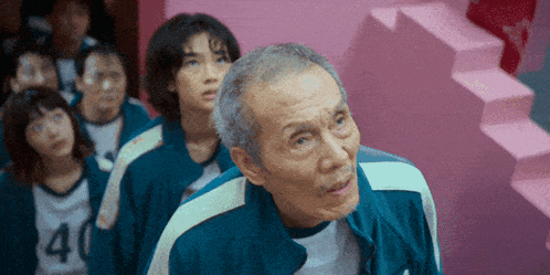 a group of people are standing in a room with stairs and a man is wearing a number 40 jersey .