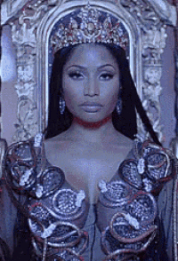a woman wearing a crown and a dress is sitting in a chair .