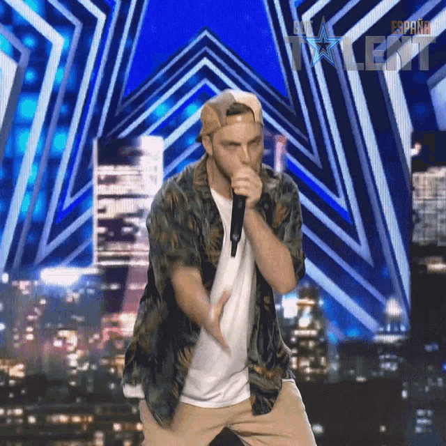 a man singing into a microphone on a stage with a sign that says espana