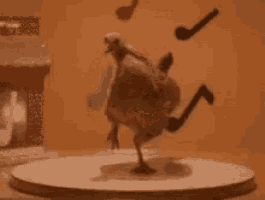 a chicken is standing on its hind legs on a round table with a pipe hanging from its tail .