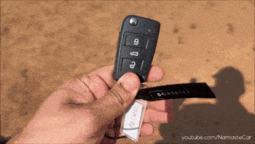 a person is holding a car key with a tag that says bc910117