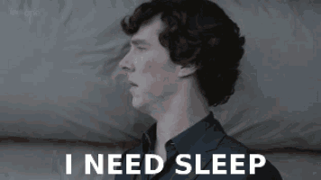 a man in a suit is laying on a bed with the words `` i need sleep '' written above him .