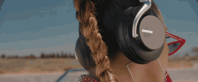 a woman wearing a pair of shure headphones with braided hair