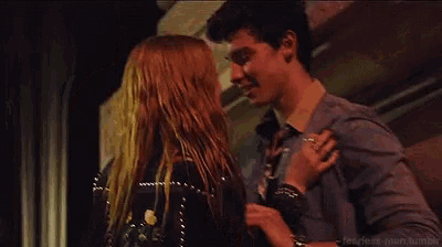 a man and a woman are dancing together in a dark room .