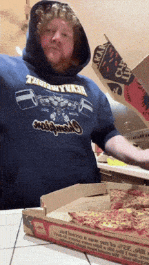 a man wearing a shirt that says ' heavyweight ' on it is holding a box of pizza