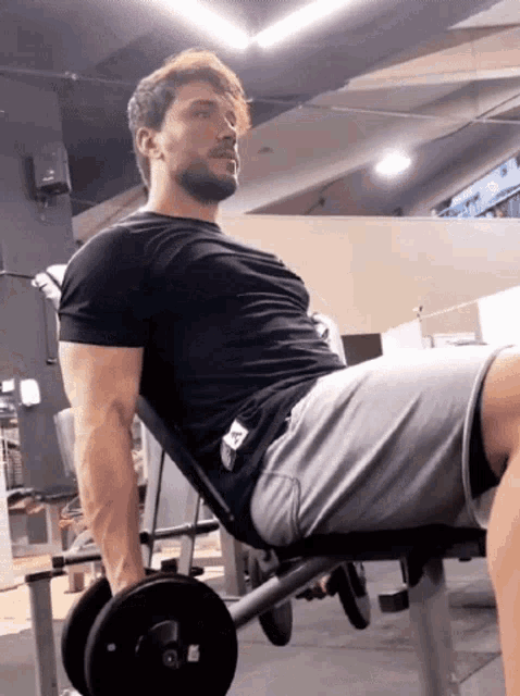 a man in a black shirt is lifting a dumbbell