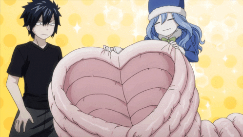 a boy and a girl are standing next to a heart shaped pillow