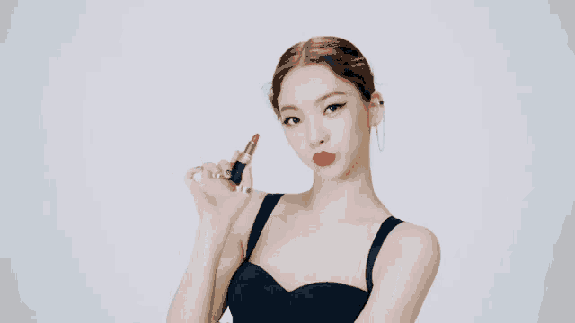 a woman with red lips is holding a red lipstick