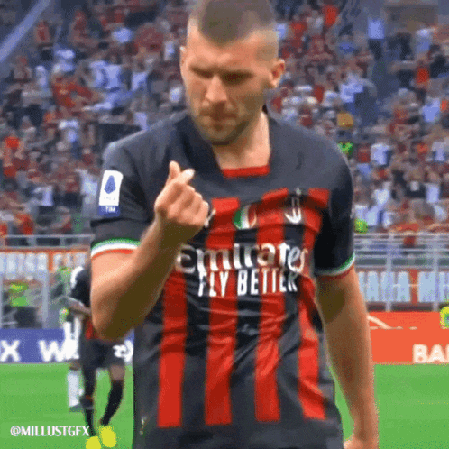 a soccer player wearing an emirates fly better shirt