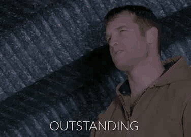 a man in a brown jacket is leaning against a wall and the word outstanding is above him