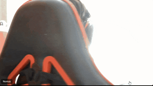 a person sitting in a chair with the word nomus on the bottom right