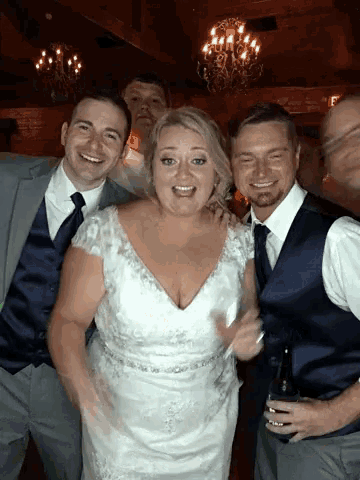 a bride and groom pose for a photo with their friends