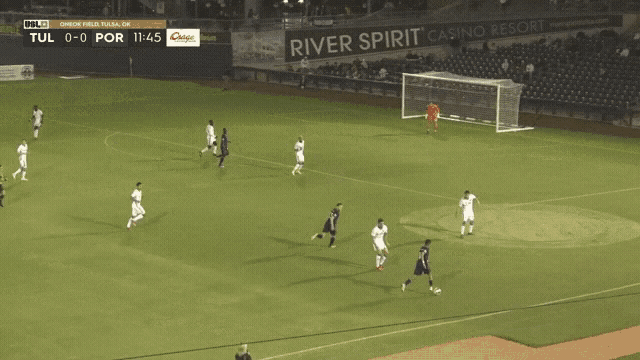a soccer game is being played in front of a river spirit casino resort sign