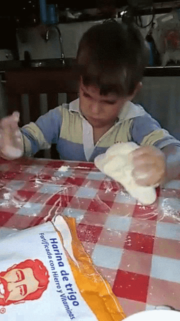 a child is playing with a bag of harina de trigo flour