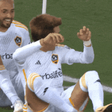 a soccer player wearing a white herbalife jersey