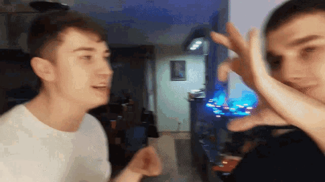 two young men giving each other a high five in a living room