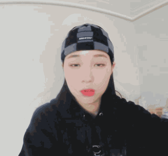 a girl wearing a black hoodie and a plaid beanie has a question mark above her head