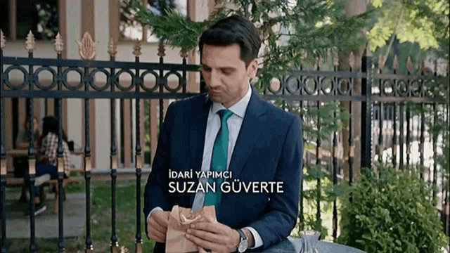 a man in a suit and tie with the name suzan guverte on the bottom right