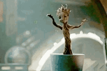 a statue of groot from guardians of the galaxy is dancing in a cup .