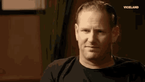 a man in a black shirt is making a funny face with his eyes closed and his mouth open .