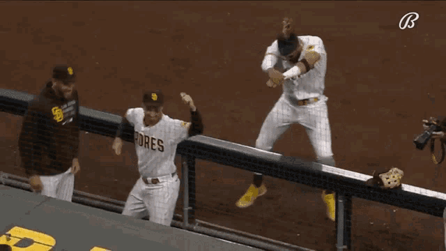 three padres baseball players are celebrating a win on the field