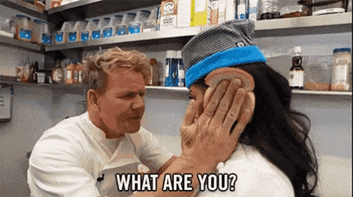 a man is holding a piece of bread over a woman 's face and asking her what are you ?