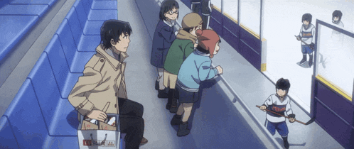 a group of people are watching a hockey game and one of them is wearing a jersey that says ' toronto ' on the front