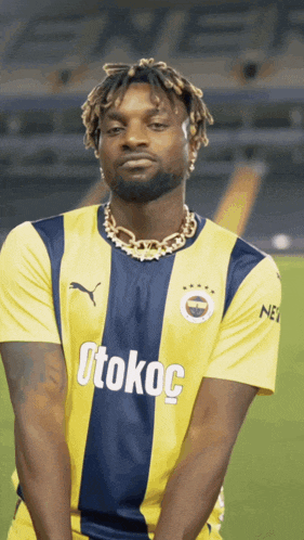 a man wearing a yellow and blue otokoc jersey