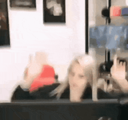 a blurry picture of a woman waving her hand in front of a computer screen .