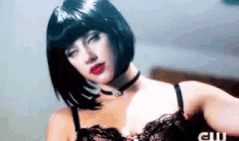 a woman is wearing a wig and a choker while wearing lingerie .