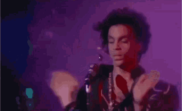 a man is singing into a microphone in a dark room .