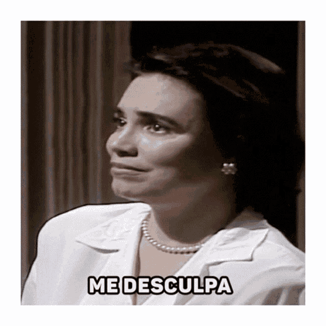 a woman in a white shirt and pearls has the word me desculpa above her