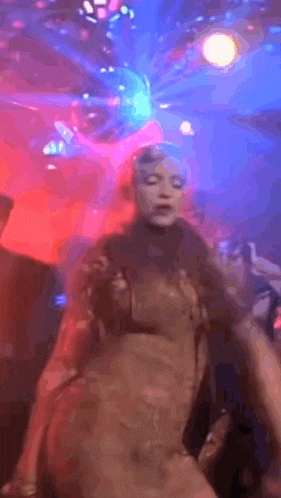 a woman in a bikini is dancing in a club with a lot of lights .