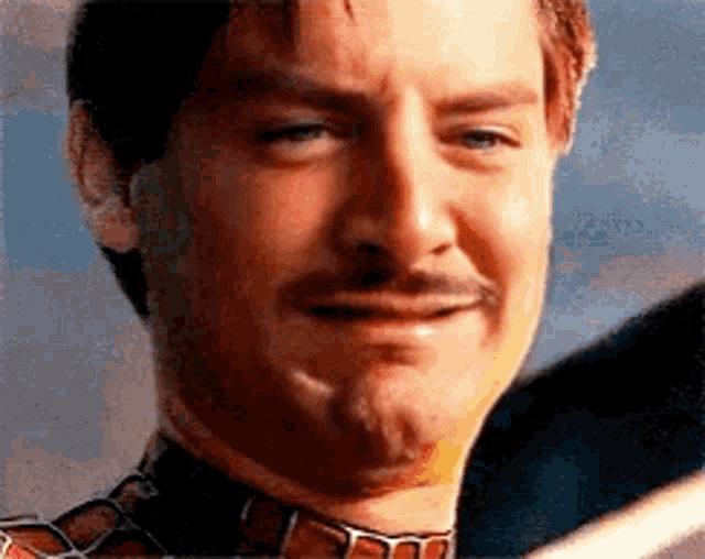 a close up of a man 's face with a beard and mustache making a funny face .