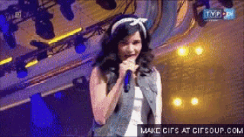 a woman singing into a microphone on tvp