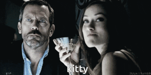 a man holding a martini glass next to a woman with the word kitty written on the bottom