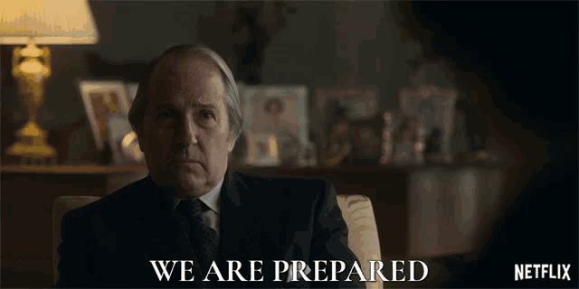 a man in a suit and tie sits in front of a netflix ad