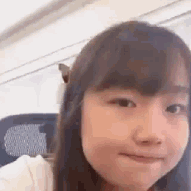 a close up of a young girl making a funny face while sitting on a plane .