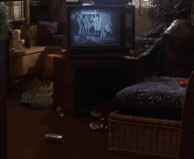 a wicker chair sits in a living room next to a tv