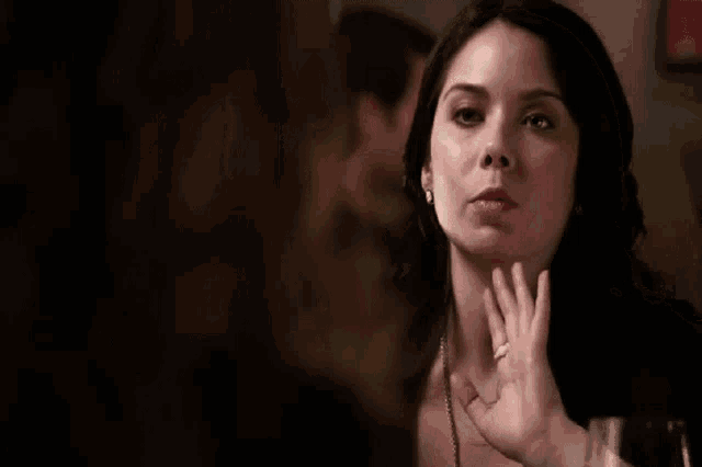 a woman is talking to another woman and waving her hand .